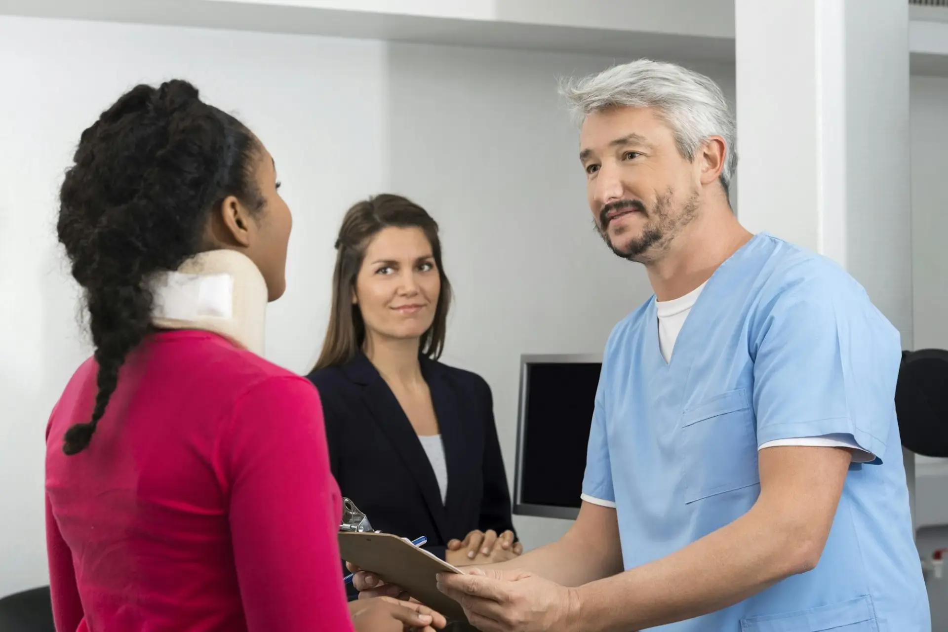 An auto accident chiropractor consulting with a patient wearing a neck brace to discuss treatment and recovery for whiplash injuries.